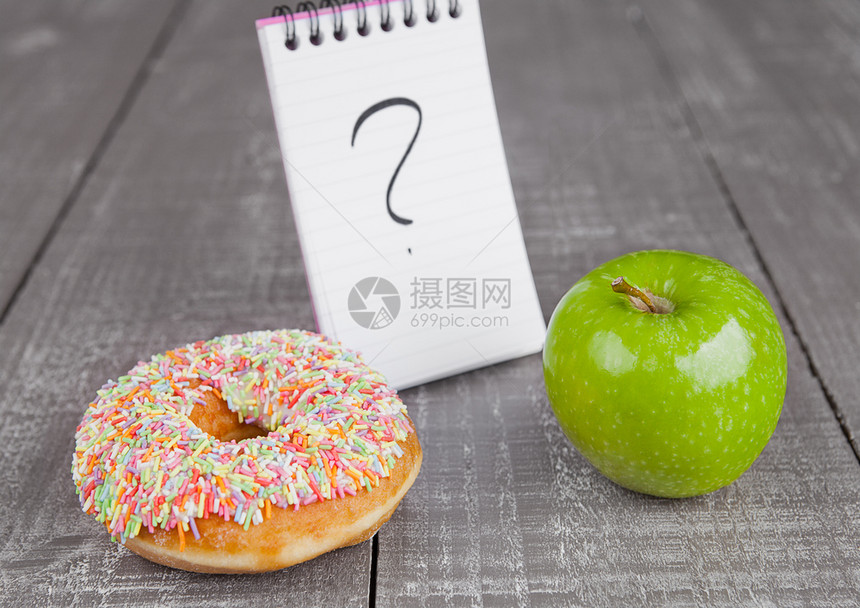 以木板为背景的甜圈和苹果健康食品选择图片