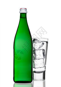 绿色的闪亮矿泉水瓶白底带玻璃和冰立方体图片