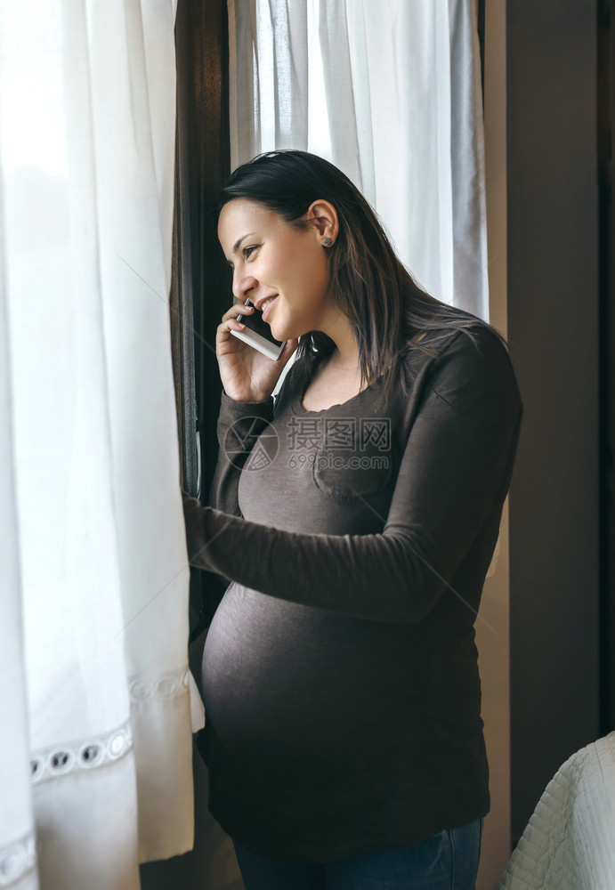 孕妇微笑着用手机说话图片