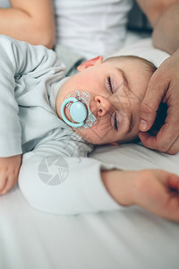 婴儿在父母爱抚他时睡觉图片