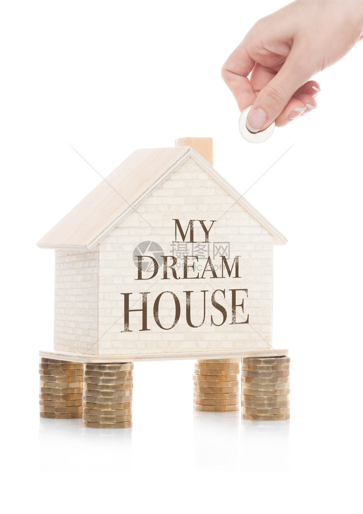 站在硬币上手拿着带有概念文字的木制房屋模型图片