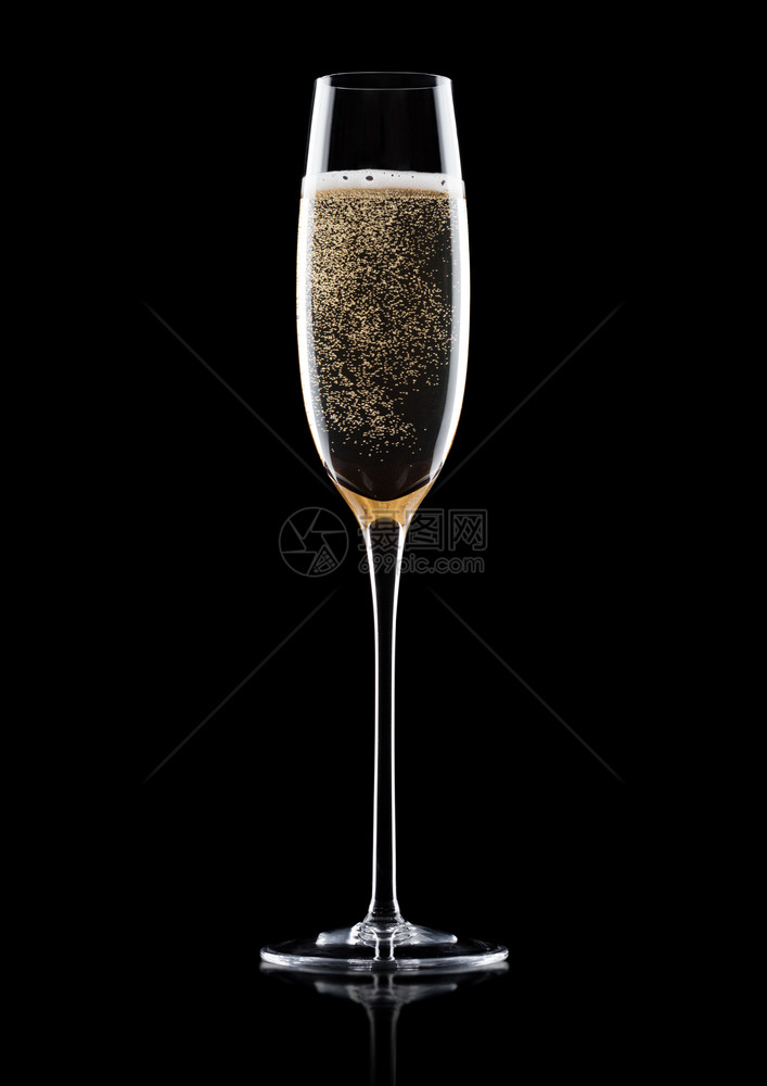 优雅的黄色香槟杯子黑背景的泡和反光图片