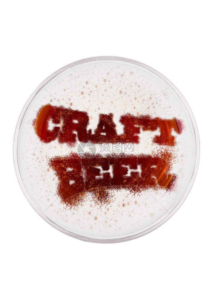 白色背景顶视图上方有手工艺啤酒字母形状的玻璃红色啤酒杯图片