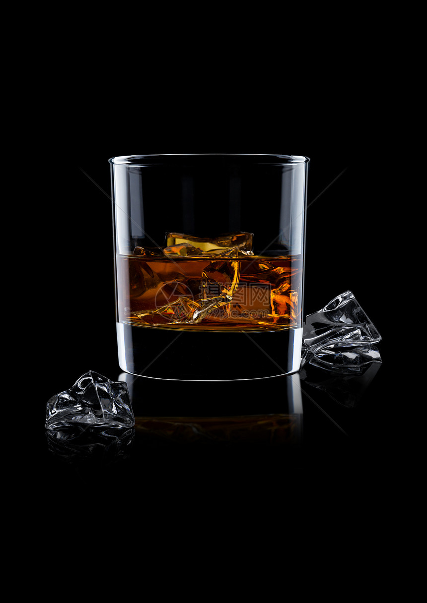 优雅的威士忌杯子冰块在黑色背景上反射图片