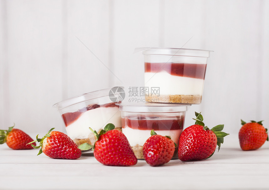 装有草莓奶油甜品的塑料容器木背景鲜草莓图片