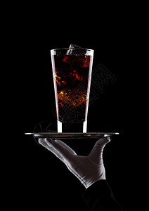 手持套托盘上装着杯可乐苏打水黑色底有冰块图片