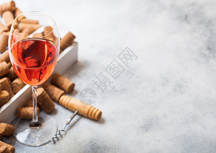 葡萄酒箱玻璃粉红玫瑰葡萄酒装有软木箱和开瓶器放在石厨房桌底顶层视图背景