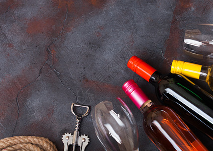 红白酒和粉玫瑰瓶上面有玻璃杯和开瓶器放在石厨房桌底图片