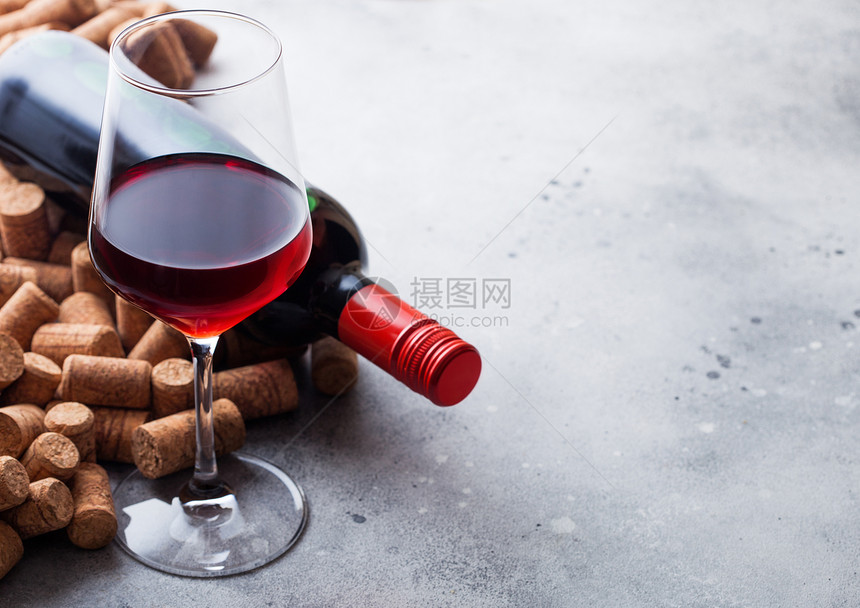 优雅的酒杯和一瓶红厨房桌底有软木塞图片