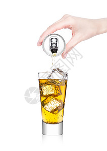 女用手将橙能量苏打饮料从铝罐倒到白底玻璃图片