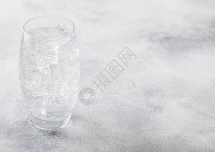 一杯闪亮的柠檬水饮料冰块和泡沫在石器厨房背景图片