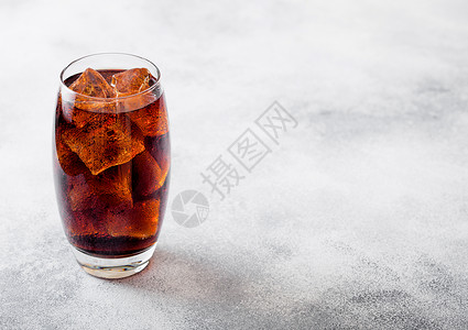 一杯可乐苏打饮料冰块和泡沫在石器厨房背景图片