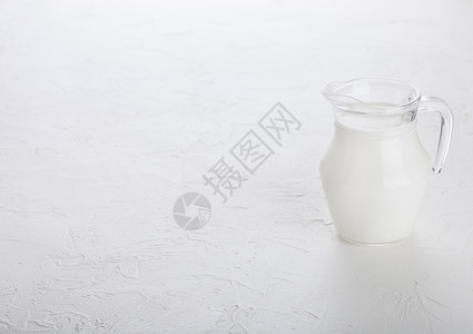 白石餐桌背景上的一罐牛奶图片