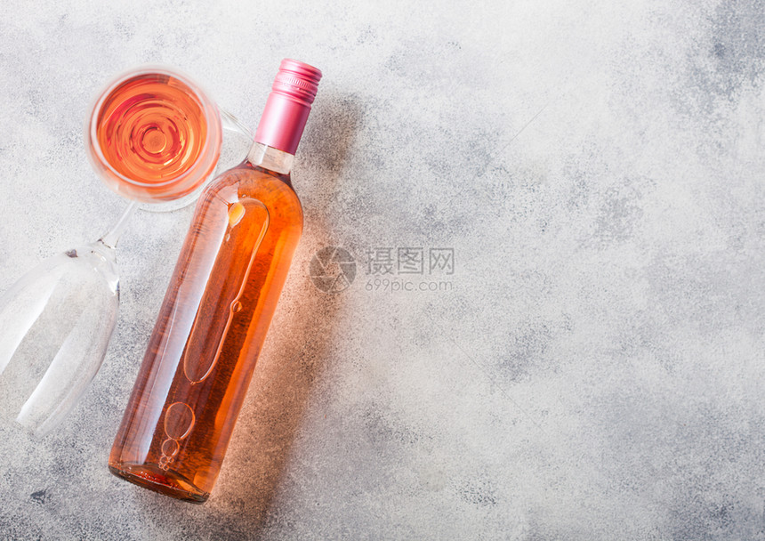 和粉红玫瑰酒的瓶子放在石头厨房餐桌背景上顶层风图片