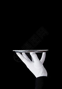 身戴白手套的女仆在黑色背景上拿着不锈钢盘背景图片