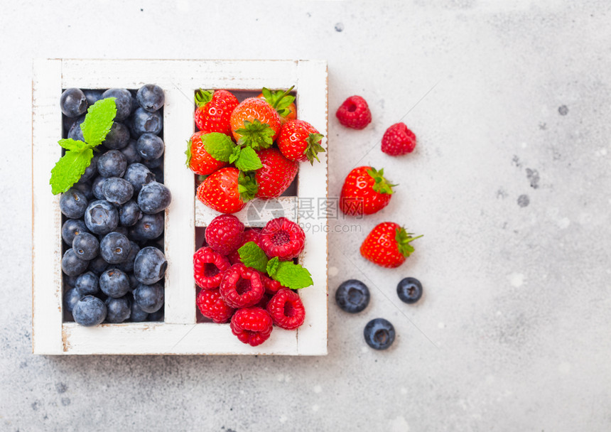 餐桌背景的白色圆边木箱中的新鲜有机果文本空间草莓蓝和薄荷叶图片