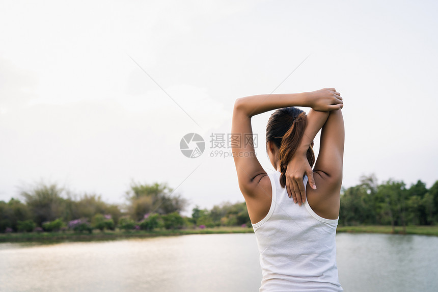 年轻健康青的跑女子在运动前给身体取暖在温的清晨公园湖边做瑜伽在城市概念中生活方式健康跃的妇女运动图片