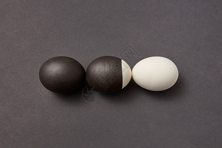 黑漆色背景上的三个鸡蛋图片