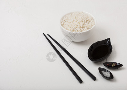 白碗加煮的有机巴斯马蒂茉米饭黑筷子和白底甜豆酱图片
