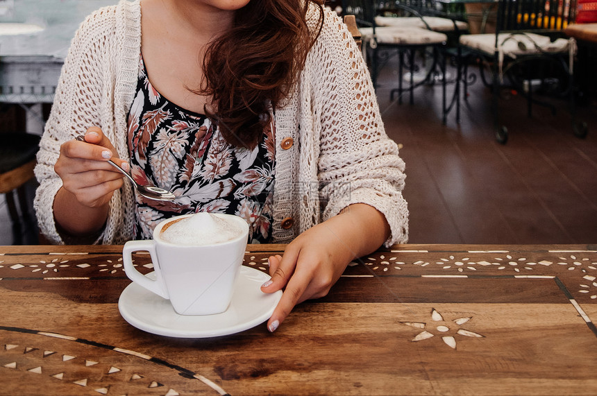 女人拿着勺子喝咖啡图片