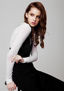 年轻美丽的时装模特身着黑色衣服和灰底白衬衫的图片