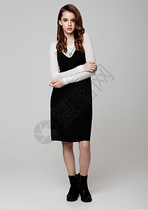 年轻美丽的时装模特身着黑色衣服和灰底白衬衫的背景图片