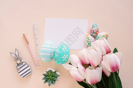 粉色郁金香和带涂鸦的鸡蛋背景图片