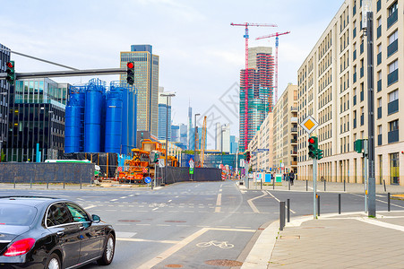 城市环境车在十字路口工业厂建筑摩天大楼工地的起重机背景德国图片