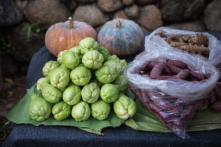 新鲜绿色茶叶紫甘薯南瓜和姜在香蕉叶上摊位蔬菜市场图片