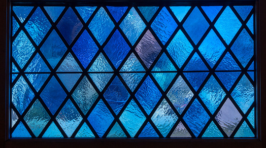 在天主教堂的彩色玻璃窗上蓝色钻石子在美国天主教堂的彩色玻璃窗上蓝钻石子上背景图片