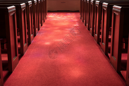红地毯教堂过道之间有红地毯的教堂过道在上有彩色玻璃窗的灯光照亮有彩色玻璃窗的光线背景图片