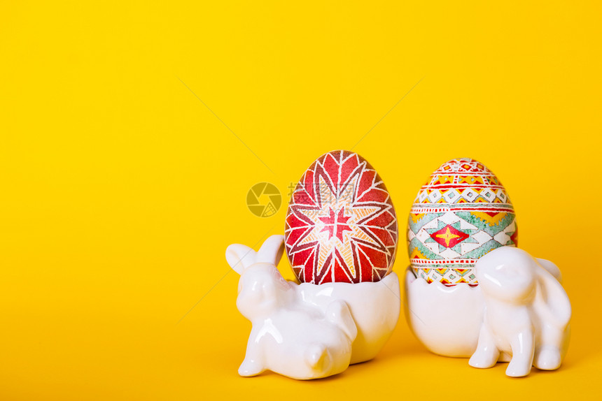 黄色背景的陶瓷兔子和彩蛋图片