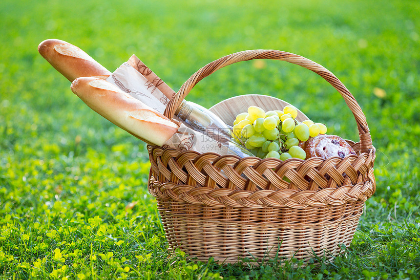 快乐的夏天在草地野餐面包葡萄酒眼镜芝士饼篮子里的面包图片