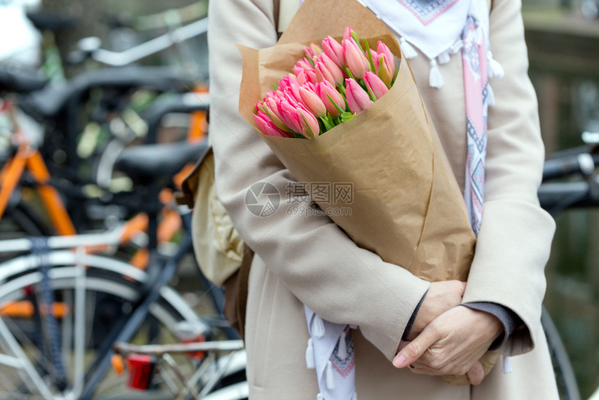 女孩在阿姆斯特丹街的长凳上坐着一束郁金香图片
