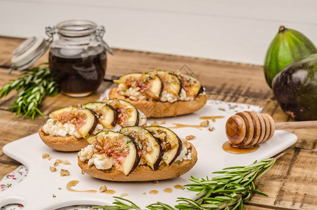 餐板上带有无花果奶酪迷迭香蜂蜜和胡桃的瑞典吐司高清图片