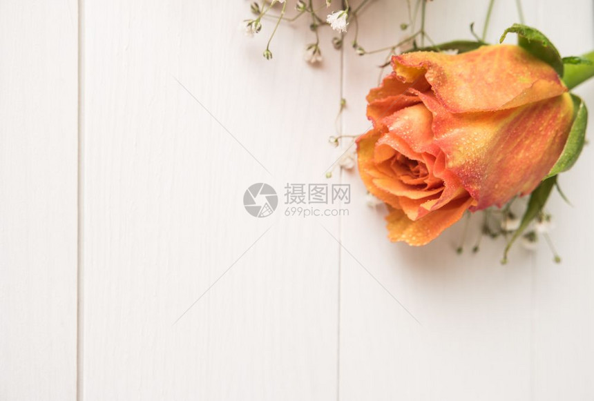 一束橙色玫瑰和木制桌上的吉卜赛人图片