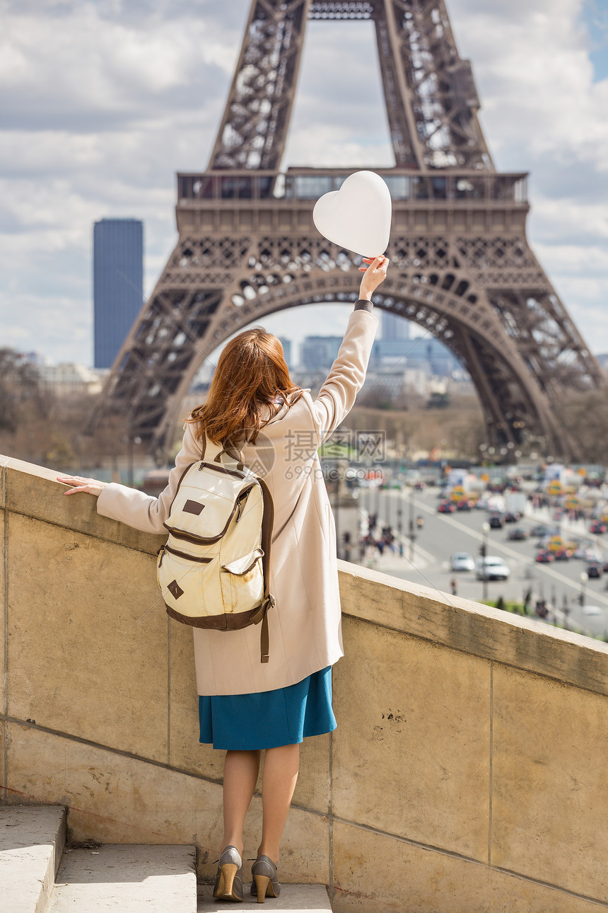 穿梭于欧洲女孩与气球以心脏的形状位于法国埃菲尔塔的背景图片