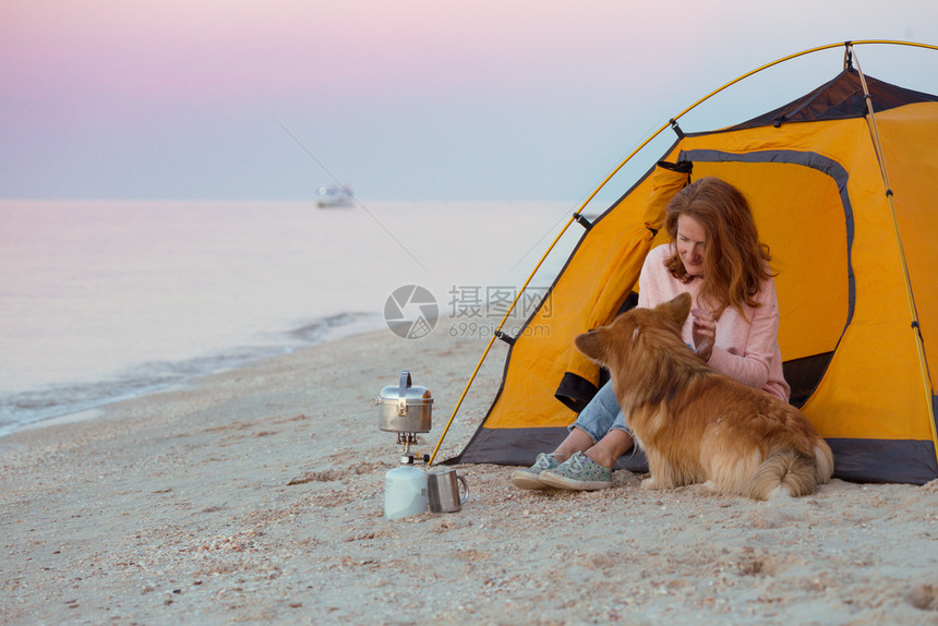 早晨在海滩的帐篷里带着一条狗的女孩在阿佐夫海边的乌拉尼风景图片