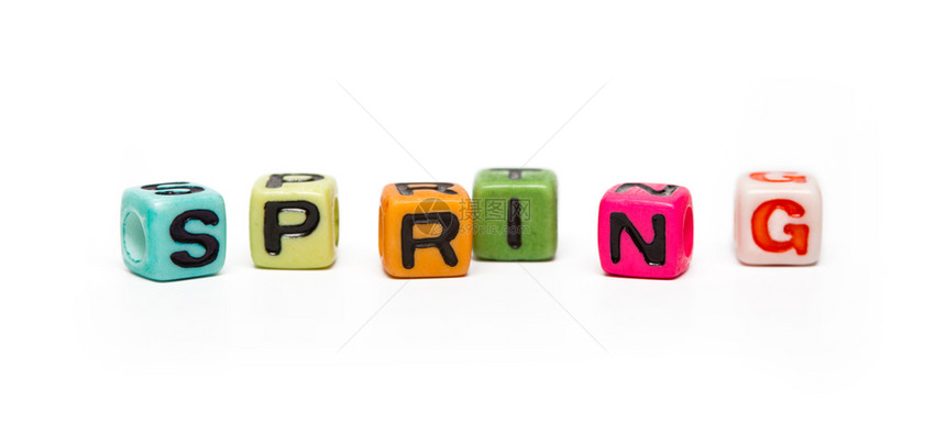 弹簧词由带有字母的多色子玩具立方体制成图片