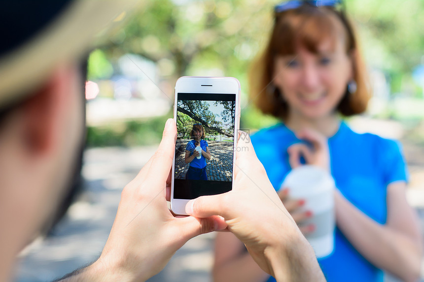 快乐的年轻夫妇用智能手机照相拍图片