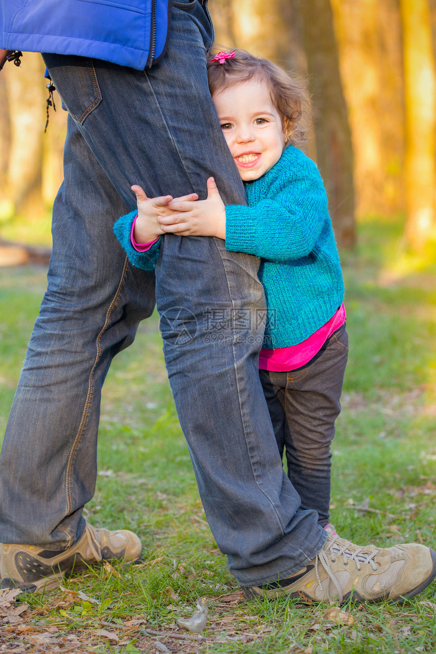 小女孩微笑和拥抱父亲腿家庭图片
