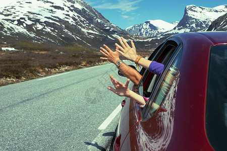 男人和孩子的手从车外对着山的背面图片