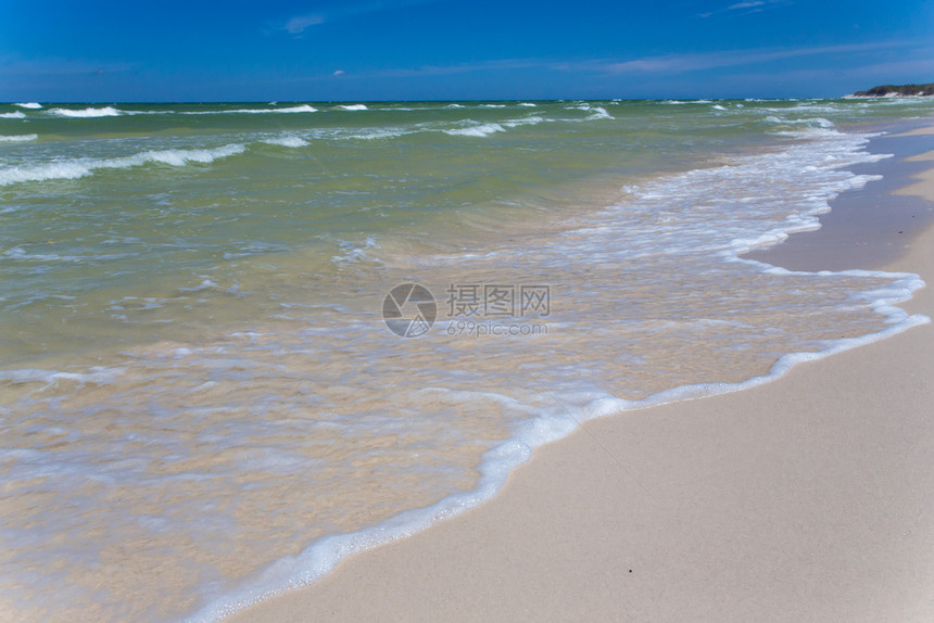 沙空海滨在清蓝天空有冲浪波图片