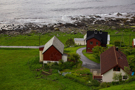 位于环岛北部的礁海边岩石岸的红色住宅背景图片