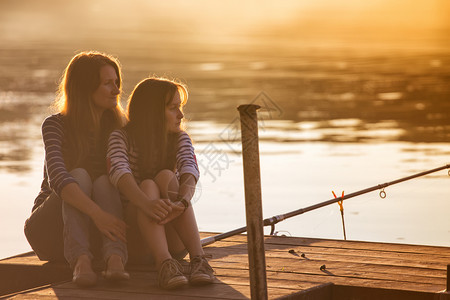 妈妈和女儿坐在达尼河岸高清图片