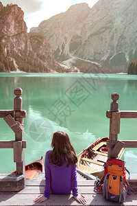 女孩背包坐在码头上看着布丽丝湖多洛米特意大利图片