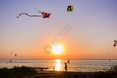 基里利夫卡女孩在日落时海边放风筝背景