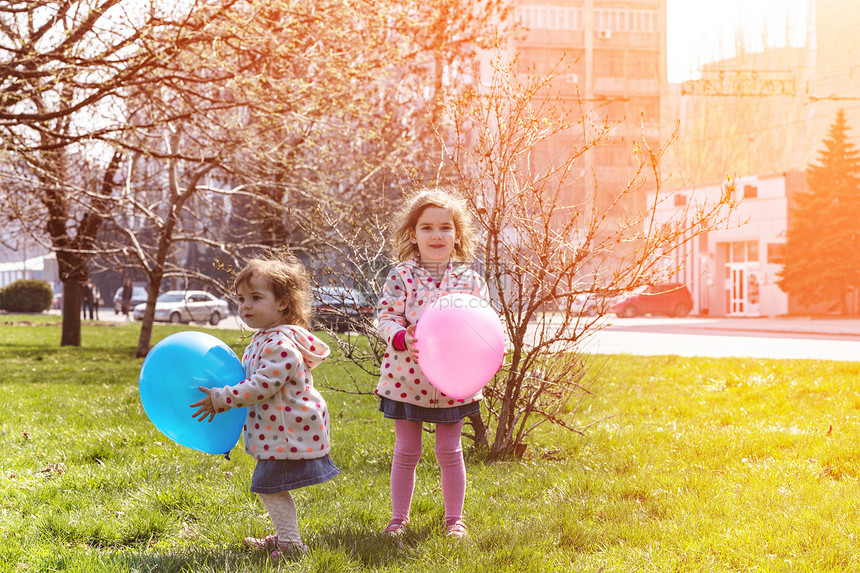 带着气球的小姐妹们在公园里玩图片