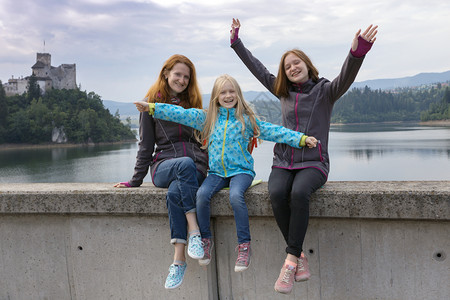 母女三人坐在河边开心的摆着姿势看着镜头图片