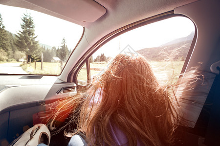 快乐的美丽女孩乘坐一辆汽车穿过山顶的多洛米特人意大利图片